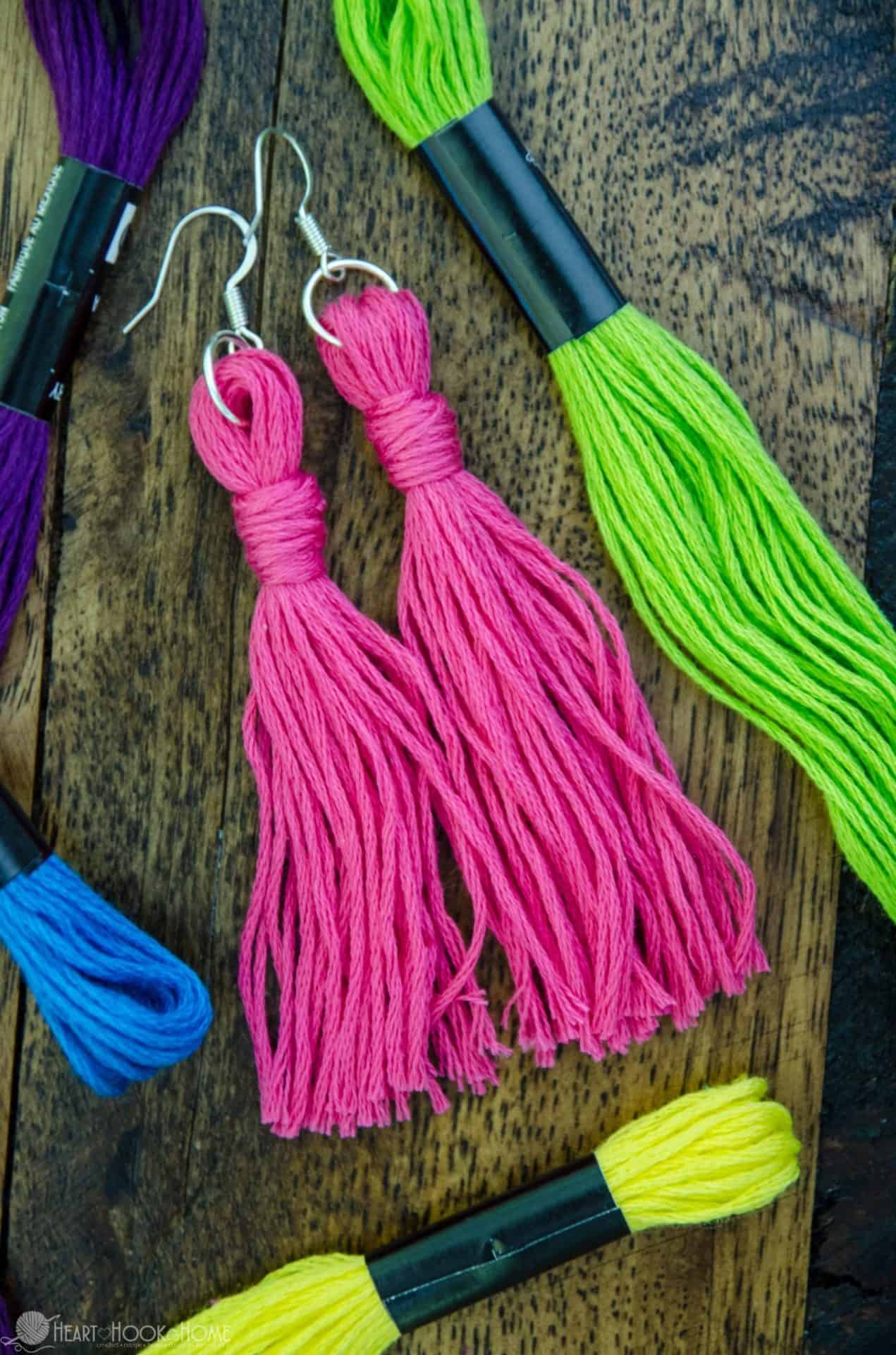 Pink example of the Quick & Easy DIY Embroidery Floss Earrings Tutorial and unused green and blue embroidery floss.