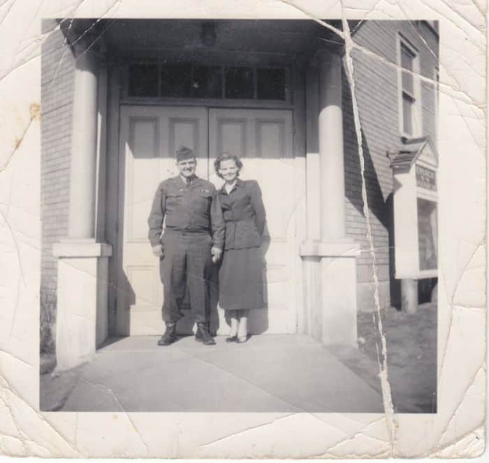 Old black and white picture of a man and woman standing in an entryway.